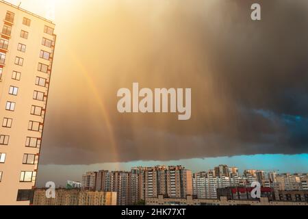 Mehrstöckige Gebäude Apartments in der regen Abend Sonnenuntergang Regenbogen, Stadt entfernt Stockfoto