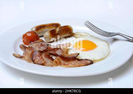 Spiegelei, gebratener Speck und Würstchen auf dem Teller Stockfoto