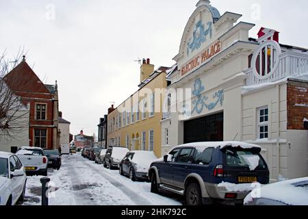 Die Frontfassade des Electric Palace, eines der ältesten noch existierenden Kinos, Harwich, Großbritannien. Historische Straße mit geparkten Autos und Schnee. Stockfoto