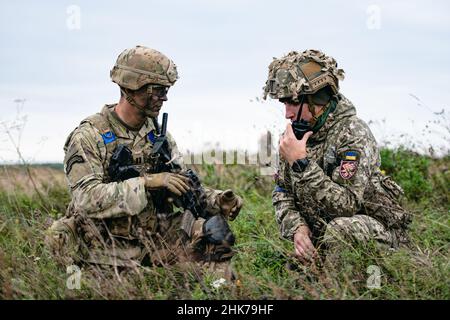 Yavoriv, Ukraine. 2nd. Februar 2022. Ein Fallschirmjäger der US-Armee, der dem Bataillon 1st zugewiesen wurde, 503rd Fallschirmjäger-Regiment koordiniert die Einrichtung einer gemeinsamen Sicherheitshaltung in einer Fallzone mit einem Fallschirmjäger der litauisch-polnisch-ukrainischen Brigade, nachdem er eine gemeinsame Luftoperation durchgeführt hatte. Dieses Training ist Teil der Übung Rapid Trident 21 im Internationalen Sicherheitszentrum für Friedenssicherung in der Nähe Stockfoto