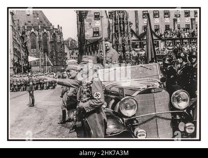 Adolf Hitler steht in seinem offenen Mercedes-Wagen bei der Nürnberger Rallye 1935, Deutschland - SA Sturmabteilung politische Milizen Truppen der Nazi-Partei marschieren bei einer Parade in der Stadt an Adolf Hitler vorbei. Der 1930er Jahre Adolf Hitler mit Hakenkreuzarmband in Militärparade, stehend in einem offenen Mercedes-Wagen mit Heil Hitler grüßen die vorbeimarschierenden Sturmabteilungstruppen Hermann Goring im Vordergrund Nürnberg Deutschland Goring und Hess sind im Vordergrund zu sehen Stockfoto