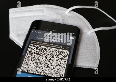 FFP2 Maske und iPhone mit Corona Warnungs-App mit QR-Code für Wiederherstellungszertifikat, symbolisches Bild Smartphone-Apps zum Schutz vor Stockfoto