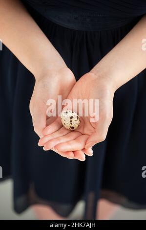 Frau mit Ei in der geschöpften Hand Stockfoto