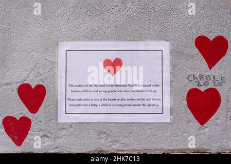 Todesfälle von Kindern an der National Covid Memorial Wall in Lambeth, London, Großbritannien. Rote Herzen, die auf eine Wand gezogen werden, die jeden Tod von COVID 19 darstellt Stockfoto