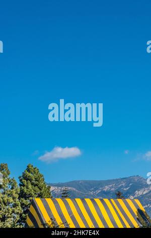 Eine hohe Kirche Mit A-Rahmen und Dach, die zur Begasung mit einer gestreiften Plane mit geometrischem und abstraktem Effekt betagt ist. Stockfoto