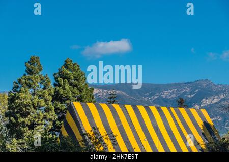 Eine hohe Kirche Mit A-Rahmen und Dach, die zur Begasung mit einer gestreiften Plane mit geometrischem und abstraktem Effekt betagt ist. Stockfoto