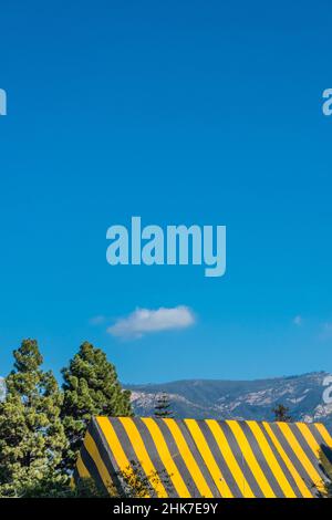 Eine hohe Kirche Mit A-Rahmen und Dach, die zur Begasung mit einer gestreiften Plane mit geometrischem und abstraktem Effekt betagt ist. Stockfoto