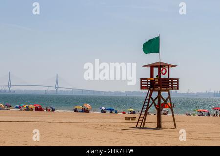 Rettungsschwimmer, die vom valdelagrana, strand-Wachturm von adiz beobachten, um die Badegäste beim Sonnenbaden am Ufer und beim Baden im Meer zu schützen Stockfoto