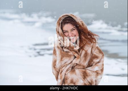 Kaukasische Frau im Winter in ein kariertes Mädchen eingewickelt. Stockfoto