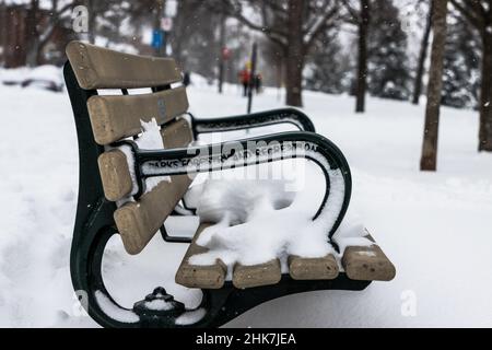 Parkbank mit Schnee bedeckt Stockfoto