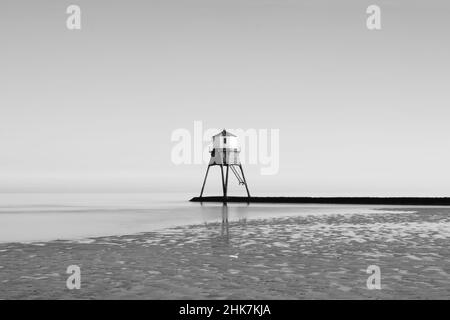 Eine Langzeitaufnahme an einem klaren Tag, an dem die Flut um den Causeway und den Dovercourt Lighthouse, Harwich & Dovercourt Bay, Essex, Großbritannien, hereinkommt Stockfoto