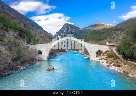 Die große gewölbte Steinbrücke von Plaka am Arachthos-Fluss, Tzoumerka, Griechenland. Stockfoto