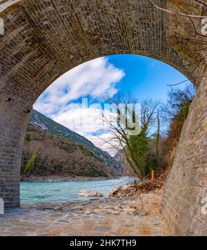 Die große gewölbte Steinbrücke von Plaka am Arachthos-Fluss, Tzoumerka, Griechenland. Stockfoto