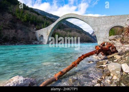 Die große gewölbte Steinbrücke von Plaka am Arachthos-Fluss, Tzoumerka, Griechenland. Stockfoto