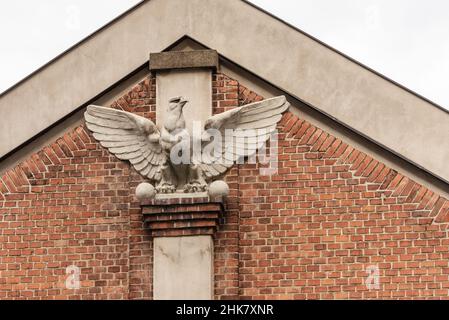 Bas-Relief am Haus in Form eines Adlers. An der Fassade des Hauses befindet sich ein großer Adler, der seine Flügel ausbreitet Stockfoto