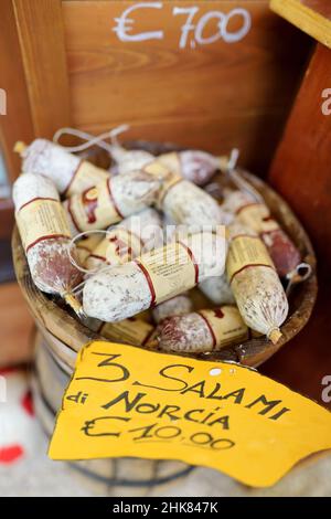 NORCIA, ITALIEN - 12. JUNI 2019: Wurstwaren, Wurstwaren und Salami werden als typische lokale Delikatessen verkauft. Eines der zahlreichen typischen Geschäfte, die Lebensmittel in No verkaufen Stockfoto