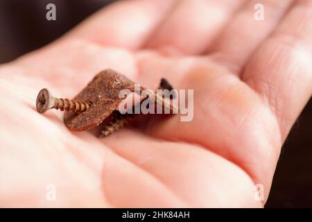 Winkel mit korrosivem Rost in der Hand eines Mannes, Stockfoto