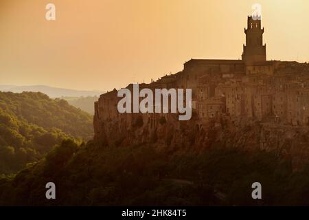 Blick auf die Stadt Pitigliano bei Sonnenuntergang, die sich auf einem vulkanischen Tuffsteinkamm befindet, der als das kleine Jerusalem bekannt ist und von üppigen Tälern umgeben ist. Etruskische Erbe, Gros Stockfoto