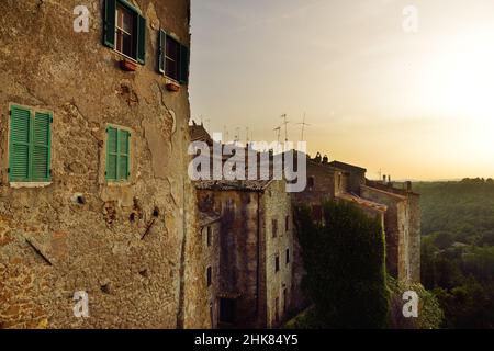 Blick auf die Stadt Pitigliano bei Sonnenuntergang, die sich auf einem vulkanischen Tuffsteinkamm befindet, der als das kleine Jerusalem bekannt ist und von üppigen Tälern umgeben ist. Etruskische Erbe, Gros Stockfoto