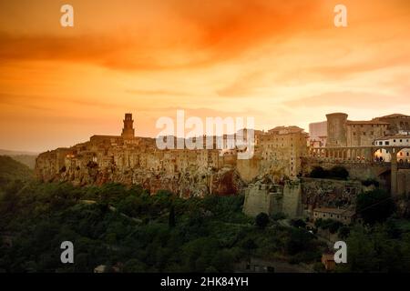 Blick auf die Stadt Pitigliano bei Sonnenuntergang, die sich auf einem vulkanischen Tuffsteinkamm befindet, der als das kleine Jerusalem bekannt ist und von üppigen Tälern umgeben ist. Etruskische Erbe, Gros Stockfoto