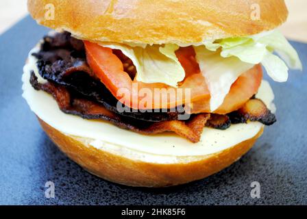 Eine Nahaufnahme eines leckeren BLT-Sandwiches auf einer frischen Kaiserrolle Stockfoto