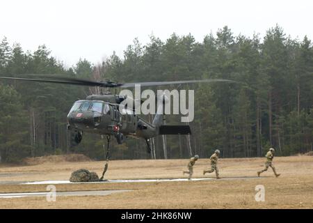 Luftangriffslehrer und Studenten führen Schlingentraglasoperationen mit UH-60 Blackhawk-Hubschraubern durch, die dem Bataillon 1st, dem Aviation Regiment 214th und dem Combat AVN 12th zugeordnet sind. Brigade, während des Luftansturzkurses der US-Armee im Trainingsgebiet Grafenwoehr, Deutschland, 27. Januar 2022. Das Combined Arms Training Center des Army Training Command 7th sponserte den zehntägigen Flugkurs, der von Ausbildern des Warrior Training Center der Army National Guard in Fort Benning, Georgia, angeboten wurde. Der Kurs schult Soldaten bei Luftangriffen, Schleuderbelastungen und Abseilen, um die Nutzung von h zu maximieren Stockfoto