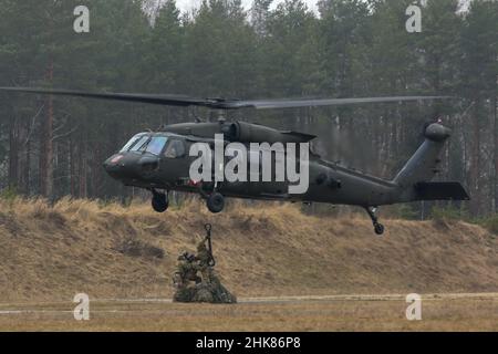 Luftangriffslehrer und Studenten führen Schlingentraglasoperationen mit UH-60 Blackhawk-Hubschraubern durch, die dem Bataillon 1st, dem Aviation Regiment 214th und dem Combat AVN 12th zugeordnet sind. Brigade, während des Luftansturzkurses der US-Armee im Trainingsgebiet Grafenwoehr, Deutschland, 27. Januar 2022. Das Combined Arms Training Center des Army Training Command 7th sponserte den zehntägigen Flugkurs, der von Ausbildern des Warrior Training Center der Army National Guard in Fort Benning, Georgia, angeboten wurde. Der Kurs schult Soldaten bei Luftangriffen, Schleuderbelastungen und Abseilen, um die Nutzung von h zu maximieren Stockfoto