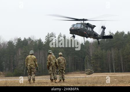 Luftangriffslehrer und Studenten führen Schlingentraglasoperationen mit UH-60 Blackhawk-Hubschraubern durch, die dem Bataillon 1st, dem Aviation Regiment 214th und dem Combat AVN 12th zugeordnet sind. Brigade, während des Luftansturzkurses der US-Armee im Trainingsgebiet Grafenwoehr, Deutschland, 27. Januar 2022. Das Combined Arms Training Center des Army Training Command 7th sponserte den zehntägigen Flugkurs, der von Ausbildern des Warrior Training Center der Army National Guard in Fort Benning, Georgia, angeboten wurde. Der Kurs schult Soldaten bei Luftangriffen, Schleuderbelastungen und Abseilen, um die Nutzung von h zu maximieren Stockfoto