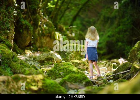 Junge Mädchen wandern in Botro ai Buchi del Diavolo, felsige Schlucht Wanderweg, entlang ausgetrockneten Fluss. Schöner Fußweg in den Wald n Stockfoto