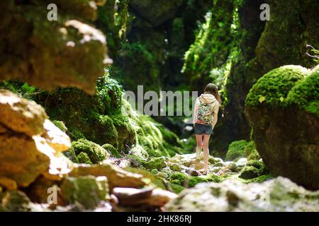 Junge Mädchen wandern in Botro ai Buchi del Diavolo, felsige Schlucht Wanderweg, entlang ausgetrockneten Fluss. Schöner Fußweg in den Wald n Stockfoto