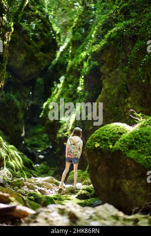 Junge Mädchen wandern in Botro ai Buchi del Diavolo, felsige Schlucht Wanderweg, entlang ausgetrockneten Fluss. Schöner Fußweg in den Wald n Stockfoto