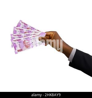 Schwarze Hand mit Anzug, der 3D gerenderte indische Rupien-Noten auf weißem Hintergrund hält Stockfoto