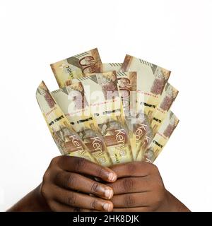 Schwarze Hände mit 3D gerenderten 1000 kenianischen Schilling-Noten. Nahaufnahme der Hände mit kenianischen Währungsscheinen Stockfoto