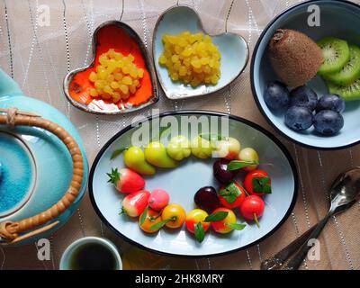 Tee Zeit Nahaufnahme von thailändischem Dessert köstliche Nachahmungen Früchte und geknicktes goldenes Eigelb Einstellung in herzförmiger Form kleine bunte Gerichte valentinstag mit Liebe Stockfoto