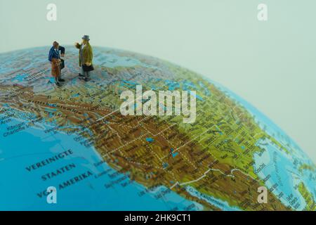 Miniatur-Geschäftsleute, die in der Region der Vereinigten Staaten von Amerika auf einer Welt stehen. Stockfoto