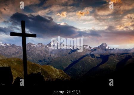 Gipfelkreuz auf dem Nufenenpass auf 2478 m, im Hintergrund die Berner Alpen mit dem Finsteraarhorn 4274 m und Lauteraarhorn 4043 m, Kanton Vala Stockfoto