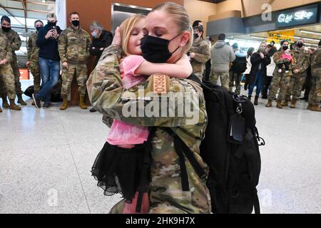 Fargo, North Dakota, USA. 20th Januar 2022. U.S. Air Force Senior Master Sgt. Erika Carruth, vom Force Support Squadron von 119th, hält ihre Tochter fest, als sie von Familie und Freunden bei ihrer Rückkehr von einem sechsmonatigen Einsatz nach Südwestasien am Hector International Airport, Fargo, North Dakota, am 20. Januar 2022 begrüßt wird. Der Einsatz war ein regelmäßiger Einsatz von Reservekomponenten (RCP) zur Unterstützung der Struktur der Operationen der US-Luftwaffe (AEF). Quelle: U.S. National Guard/ZUMA Press Wire Service/ZUMAPRESS.com/Alamy Live News Stockfoto