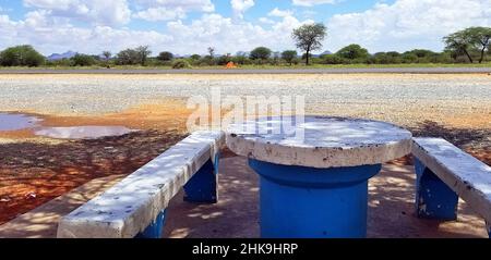 Ein blau-weißer Steintisch an einem Rastplatz auf der Straße zwischen Rehoboth und Windhoek, Namibia. Stockfoto