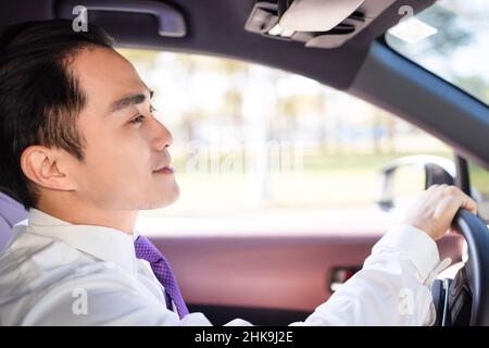 Hübscher junger Mann, der das Auto fährt Stockfoto