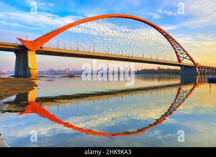 Bugrinsky Brücke im goldenen Herbst. Die Stütze einer gewölbten Automobilbrücke am Ufer des ob am Rande einer Großstadt. Nowosibirsk, S Stockfoto