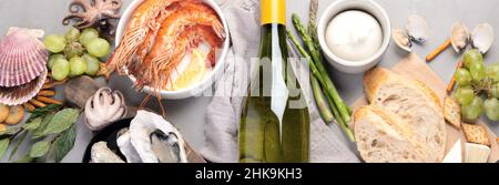 Weißweinflasche auf grauem Hintergrund. Meeresfrüchte und Vorspeisen. Draufsicht, flach liegend, Panorama Stockfoto