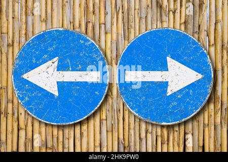 Altes blaues metallisches Pfeilschild gegen die Trennung der Lattenarbeit, das anzeigt, nach links und rechts zu gehen - Konzeptbild. Stockfoto