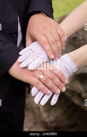 Hände von Jungvermählten, Goldringen und Hochzeitsgesellschaft Stockfoto