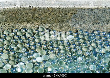 Iida, nagano, japan, 2022/03/02 , kleine Glasmarmore, eingetaucht in das Wasser am Eingang des Motozenkouji-Tempels. Es hat eine starke Beziehung zu Stockfoto