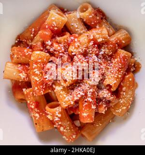 Nahaufnahme der Schale von Amatriciana. Italienische Pasta Rezept mit Tomatensauce, Speck und Parmesan auf der Oberseite.Tomatensauce Macaroni. Italienisches Essen. Carb-Diät, mit Stockfoto