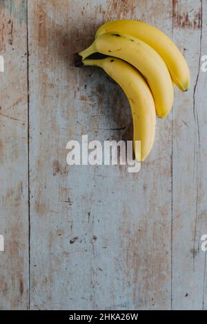Drei Bananen auf einem Holztisch mit Platz zum Kopieren Stockfoto