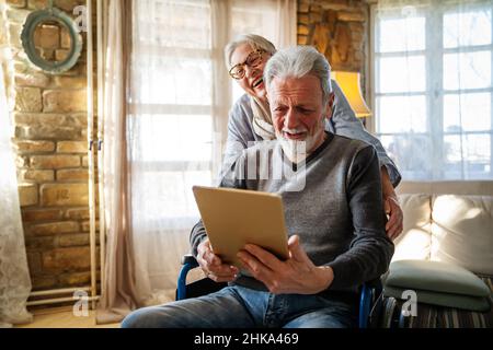 Älteres Paar Spaß haben und lachen, während Sie mit ihrem Tablet pc Computer. Stockfoto