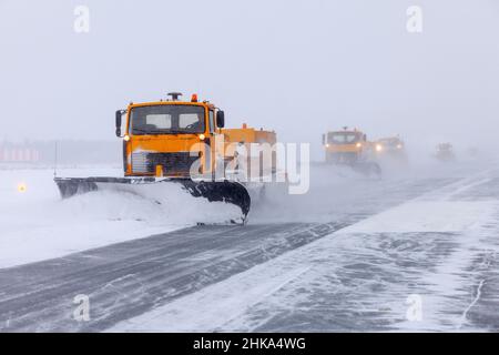 Der Schneepflug reinigt nach starkem Schneesturm auf der Piste. Stockfoto