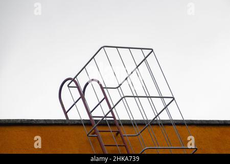 Feuertreppe auf der Oberseite eines Gebäudes, Stahlkäfigleiter Stockfoto