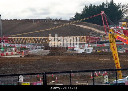 Harefield, Uxbridge, Großbritannien. 2nd. Februar 2022. HS2 auf dem riesigen High Speed 2-Gelände in der Harvil Road am Stadtrand von Harefield werden die Bauarbeiten fortgesetzt. Die Harvil Road wird vom 7th. Bis 20th. Februar geschlossen, sodass HS2 mit Erdarbeiten und Anhäufungen beginnen kann, um eine dauerhafte Struktur zu bauen, die den Süddamm des Viadukts von HS2 bilden wird. Die Einheimischen sind durch die Auswirkungen der Umweltschützer am Boden zerstört, und die Einheimischen sind sehr besorgt über die Auswirkungen des Tunnels HS2 und der Arbeiten auf die Trinkwasserversorgung. Quelle: Maureen McLean/Alamy Stockfoto